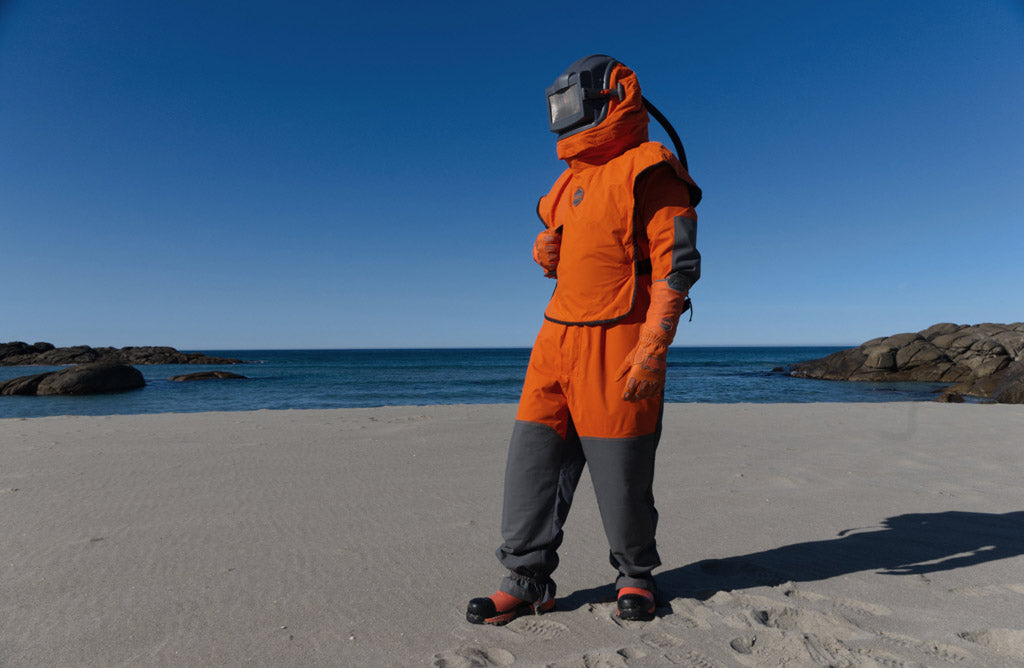 Man met het Blastsafe Origin pak aan op het strand